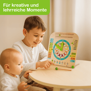 Zwei Kinder sitzen am Tisch und spielen mit einer bunten Lernuhr aus Holz. Die Uhr zeigt Zahlen, Zeiger, Wochentage und Monate. Oben links steht: ‚Für kreative und lehrreiche Momente‘.