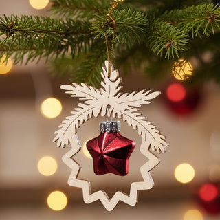 Christbaumschmuck Stern in Rot (8,5 cm), glänzende Glasstern-Kugel in einem filigranen Holzornament am Tannenbaum hängend, umgeben von grünen Zweigen und warm leuchtenden Weihnachtslichtern im Hintergrund.
