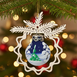 Christbaumschmuck „Winterwald“ (9 cm), farbig bemalte Glaskugel mit winterlicher Landschaft und Tannenbaum, eingefasst in ein filigranes Holzornament, am Weihnachtsbaum hängend vor warm leuchtendem Lichterhintergrund.