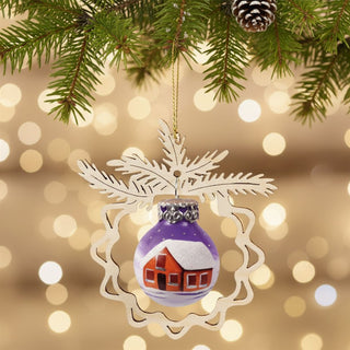Christbaumschmuck „Winterhaus“ (9 cm), farbig bemalte Glaskugel mit rotem Haus und verschneiter Winterlandschaft, eingefasst in ein filigranes Holzornament in Tannenform, am Weihnachtsbaum hängend vor warm leuchtendem Lichterhintergrund.