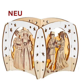 Dekorativer Teelichthalter aus Holz mit gebogener, mehrteiliger Form und ausgeschnittenen Sternmustern. Die Vorderseiten der Elemente sind weiß gestaltet, während die Rückseiten naturfarbenes Holz zeigen. Im Inneren leuchtet warmes Kerzenlicht. Auf den einzelnen Segmenten sind gravierte Märchenfiguren in historischer Kleidung zu sehen, darunter Paare beim Tanzen oder Stehen. Links oben im Bild steht in roter Schrift „NEU“.