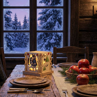 Farbiger Kerzenhalter „DEFA-Schneewittchen“ für ein Teelicht (ca. 12 cm) aus Holz, würfelförmig mit detailreichen Märchenmotiven rund um Schneewittchen und den Prinzen. Das warm leuchtende Teelicht setzt die farbigen Illustrationen stimmungsvoll in Szene. Der Kerzenhalter steht auf einem gedeckten Holztisch in einer gemütlichen Stube; im Hintergrund ist ein Fenster mit verschneiter Winterlandschaft zu sehen. Auf dem Tisch befinden sich Geschirr, Besteck sowie Äpfeln, die das Märchenthema unterstreichen.