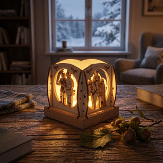 Mini-Kerzenhalter „Drei Haselnüsse für Aschenbrödel®“ 2025 für ein Teelicht (ca. 7 cm) aus naturbelassenem Holz mit filigranen Märchenmotiven. Der warm leuchtende Kerzenhalter steht auf einem Holztisch in einem gemütlichen Wohnraum; im Hintergrund ein Fenster mit winterlicher Schneelandschaft, ergänzt durch Bücher, Blätter und Haselnüsse als stimmungsvolle Dekoration.