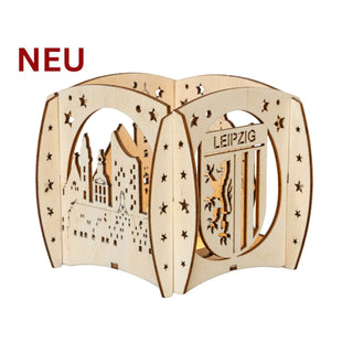 Holz‑Kerzenhalter „Stadt Leipzig“ mit filigranen Stadtsilhouetten, Sternen und dem Leipzig‑Wappen, passend für ein Teelicht; 12 cm groß.