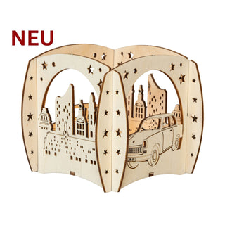 Holz‑Kerzenhalter „Trabant und Wartburg“ mit filigraner Stadtsilhouette, Sternmotiven und Autoausschnitten, passend für ein Teelicht; 12 cm groß.