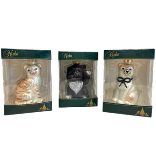 Drei Glas-Christbaumanhänger in Katzenform, jeweils einzeln in transparenter Geschenkverpackung mit grün-goldenem Pappkarton.