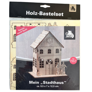 Bastelset „Stadthaus“ aus naturbelassenem Holz zum Selbstzusammenbauen. Das Modell zeigt ein mehrstöckiges Stadthaus mit Satteldach, Uhr im Giebel, großen Fenstern und dekorativer Eingangstür. Die vorgestanzten Holzteile ermöglichen einen einfachen Aufbau und laden zum kreativen Gestalten ein. Geeignet für Kinder ab 5 Jahren. Höhe ca. 12 cm.
