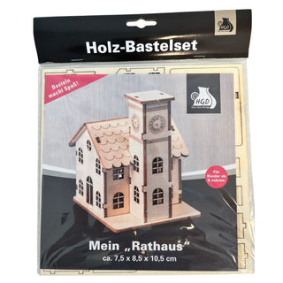 Bastelset „Rathaus“ aus naturbelassenem Holz zum Selbstzusammenbauen. Das Modell zeigt ein detailreiches Rathaus mit Uhrenturm, zahlreichen Fenstern und klassischem Satteldach. Die vorgestanzten Holzteile ermöglichen einen einfachen Aufbau und bieten viel Raum für kreatives Gestalten. Geeignet für Kinder ab 5 Jahren. Höhe ca. 11 cm.
