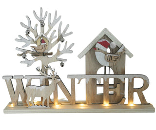 LED‑Diorama „Winter“, ca. 21 cm breit: Dekoratives Holzmotiv mit Schriftzug „WINTER“, kombiniert mit filigranen Figuren wie Reh, Bäumen und Häuschen. Mehrschichtige Gestaltung sorgt für Tiefeneffekt, während integrierte LEDs ein warmes Licht erzeugen und die winterliche Szene stimmungsvoll beleuchten.
