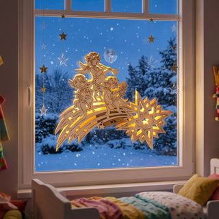 LED Fensterbild „Engel mit Sternschnuppe“ (28 cm) aus naturbelassenem Holz, warm beleuchtet, zeigt drei musizierende Engel auf einer leuchtenden Sternschnuppe, dekorativ am Fenster befestigt, vor winterlicher Schneelandschaft und umgeben von hängenden Sternen im Hintergrund.