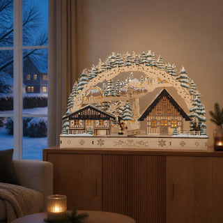 LED-Lichterbogen „Waldhaus“ mit beleuchteten Häusern, verschneiten Tannenbäumen und Kind mit Schlitten in einer farbenfrohen Winterlandschaft.