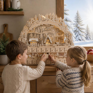 LED-Lichterbogen „Adventskalender“ aus Naturholz mit beleuchtetem Winterdorf, verschneiten Tannenbäumen und 24 Adventskalender-Schubladen, zwei Kinder öffnen gemeinsam ein Kalenderfach.