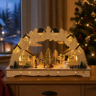 LED Lichterbogen „mit drehendem Weihnachtsbaum“ in farbiger Gestaltung mit beleuchteten Fachwerkhäusern, verschneiten Tannen, Schneemann und elektrisch drehendem Weihnachtsbaum in der Mitte, 43 cm breit.