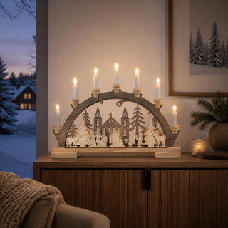 LED-Lichterbogen „Vor dem Dom“ mit sieben LED-Kerzen, winterlicher Stadtszene, Dom, Tannenbäumen, Figuren und Rehen in farbiger Gestaltung.
