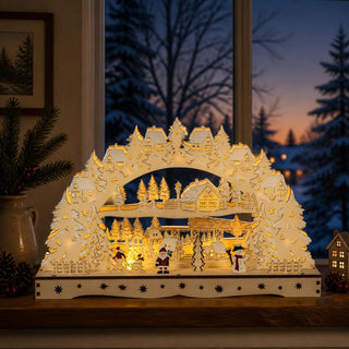 LED Lichterbogen „Santa Claus und Schneemann“, natur, 43 cm, als stimmungsvolle Weihnachtsdekoration auf einer Fensterbank. Das filigrane Holzmotiv zeigt Santa Claus, einen Schneemann, verschneite Tannen, winterliche Häuser und eine Eisenbahn in einer detailreichen Winterlandschaft. Die warmweiße LED-Beleuchtung hebt die mehrlagige Gestaltung hervor und sorgt für eine gemütliche Atmosphäre während der Advents- und Weihnachtszeit.