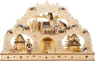 LED Lichterbogen „Winterdorf“ aus naturfarbenem Holz mit beleuchtetem Dorfmotiv, integrierter Pyramide, verschneiten Tannen und 20 warmweißen LEDs, 58 cm, batteriebetrieben.