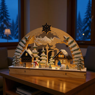 LED Lichterbogen „Lustige Schneemänner“ 45 cm auf einem Wohnzimmertisch, mit beleuchtetem Winterdorf, verschneiten Tannenbäumen, zwei Schneemännern und stimmungsvoller Weihnachtsbeleuchtung.
