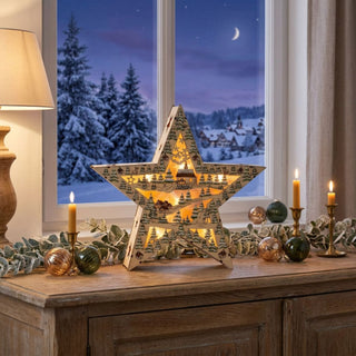 LED-Weihnachtsstern im Country Style (28 cm), aus Holz mit filigraner Winterlandschaft und warm leuchtender Innenbeleuchtung, dekorativ auf einem Sideboard vor verschneiter Fensterkulisse platziert.