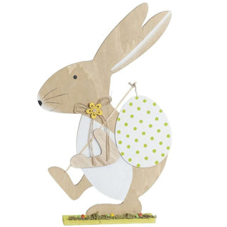 Deko-Osterhase aus Holz mit einem weißen Osterei mit grünen Punkten