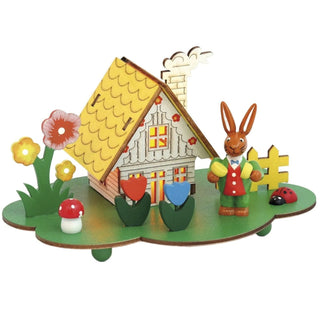 LED-Lichterhaus auf einem grünen Sockel mit bunten Blumen und einem Osterhasen