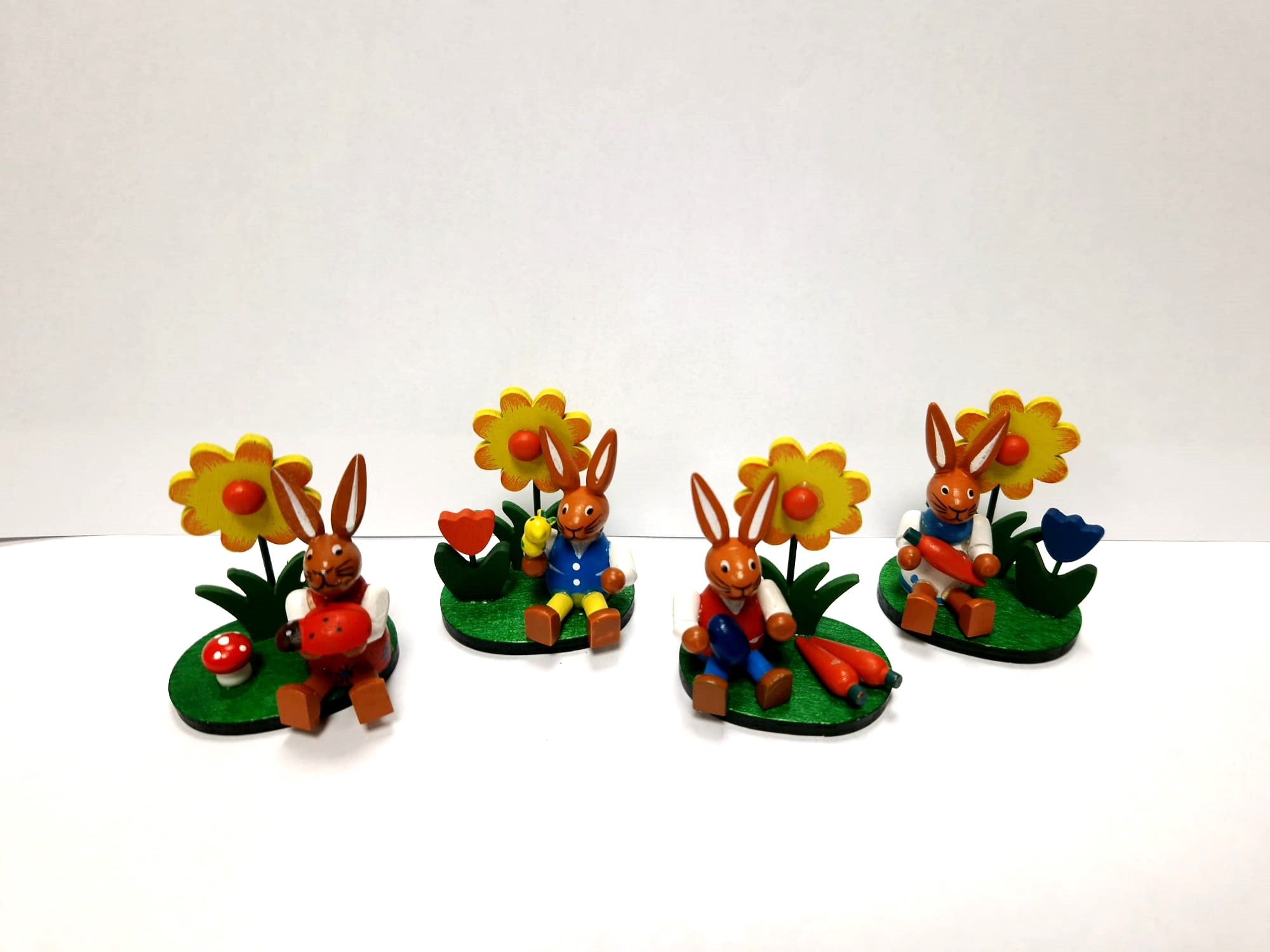 Holzfiguren Osterhasen mit Blume auf Sockel 4er-Set