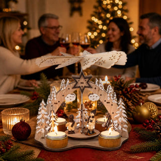 Weihnachtspyramide „Winterfreuden“ aus naturfarbenem Holz für vier Teelichter auf einer festlich dekorierten Weihnachtstafel. Die filigrane Pyramide zeigt verschneite Tannenbäume, Sterne und zwei handbemalte Figuren auf einer drehbaren Plattform. Die brennenden Teelichter setzen das große Flügelrad in Bewegung und sorgen für warmes Kerzenlicht. Im Hintergrund schaffen Weihnachtsbaumbeleuchtung, Kerzen und festliche Tischdekoration eine gemütliche und stimmungsvolle Adventsatmosphäre.