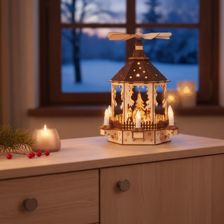 LED-Weihnachtspyramide „Schneemann“ (ca. 36 cm) aus naturbelassenem Holz, mit filigranen Wintermotiven und Schneemann-Figuren. Die mehrstöckige Pyramide ist mit warmen LED-Lichtern und kleinen Kerzenelementen ausgestattet; oben dreht sich ein Flügelrad. Die Pyramide steht auf einem Holzmöbel in einer gemütlichen Wohnstube; im Hintergrund ein Fenster mit verschneiter Winterlandschaft sowie Kerzen, die eine stimmungsvolle, festliche Atmosphäre schaffen.
