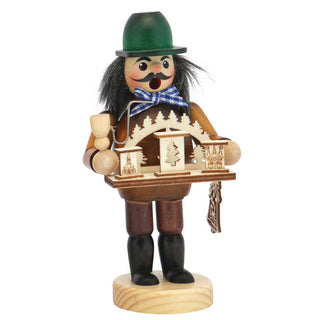 
Farbiges Räuchermännchen mit grünem Hut, Holzpfeife und Tablett mit kleinen Schwibbogen‑Miniaturen, stehend auf einem runden Holzsockel.*
