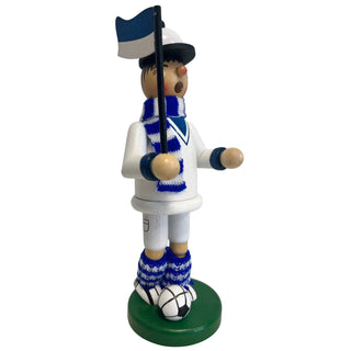 Räuchermännchen „Fußballer“ aus Holz, ca. 23 cm groß, in weiß-blauer Farbgestaltung aus seitlicher Perspektive. Die Figur steht auf einem runden grünen Sockel neben einem schwarz-weißen Fußball, trägt ein weißes Outfit mit blauen Details, einen blau-weiß gestreiften Schal sowie gestrickte Beinwärmer und hält eine blau-weiße Fahne an einem schwarzen Stab.