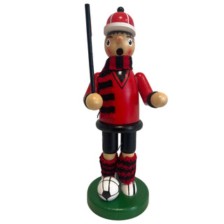 Räuchermännchen „Fußballer“ aus Holz, ca. 23 cm groß, in dunkelroter Farbgestaltung. Die Figur steht auf einem runden grünen Sockel neben einem schwarz-weißen Fußball, trägt ein dunkelrotes Outfit mit schwarzen Details, einen rot-schwarz gestreiften Schal sowie passende gestrickte Beinwärmer und hält einen schwarzen Stab in der Hand.
Geben Sie Ihr Feedback zu BizChat ab.