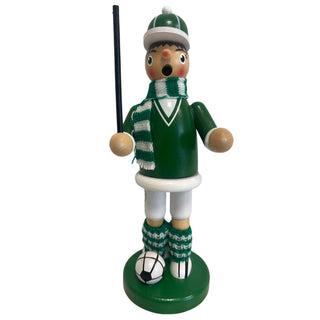 Räuchermännchen „Fußballer“ aus Holz, ca. 23 cm groß, in grüner Farbgestaltung. Die Figur steht auf einem runden grünen Sockel neben einem schwarz-weißen Fußball, trägt ein grünes Outfit mit weißem Detail, einen grün-weiß gestreiften Schal sowie gestrickte Beinwärmer und hält einen schwarzen Stab in der Hand.