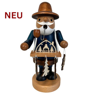Farbiges Räuchermännchen „Schwibbogenhändler“ aus Holz, 21 cm hoch, mit Pfeife und kleinem Schwibbogen am Tragegestell. Frontansicht