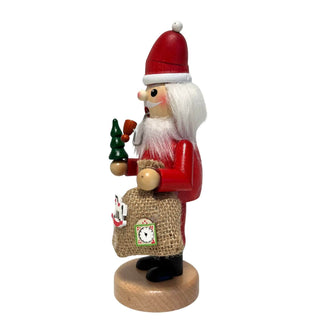 Holz-Räucherwichtel als Weihnachtsmann mit rotem Anzug, Pfeife, grünem Bäumchen und Jutesack mit Spielzeugmotiven. Seitenansicht
