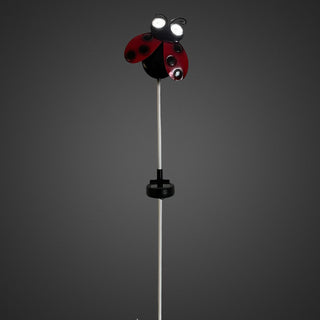 Gartenstecker „Marienkäfer“ mit rotem Körper und schwarzen Punkten, leuchtender Solar‑LED in den Augen und wechselnder Augen‑Blickrichtung, 78 cm hoch, vor dunklem Hintergrund.