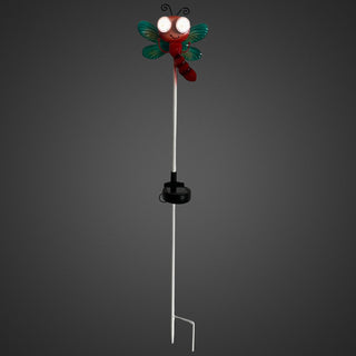 Gartenstecker „Libelle“ mit grün schimmernden Flügeln, rotem Körper und leuchtender Solar‑LED im Augenbereich, wechselnde Augen‑Blickrichtung, 77 cm hoch, vor dunklem Hintergrund.