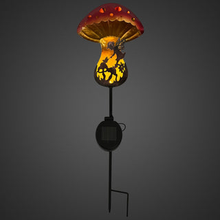 Gartenstecker „Pilz“ mit rotem Pilzkopf und warm leuchtender Solar‑LED, dekoratives Motiv im Pilzstiel, montiert auf Metallstab vor dunklem Hintergrund.