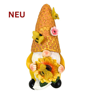 Gartenfigur eines Wichtels mit Sonnenblume und honigwabenartiger Mütze mit Bienen, Solar‑LED, 18 cm hoch.