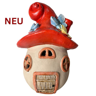 Dekohaus in Pilzform mit rotem Dach und Schmetterlingen, auf weißem Hintergrund.