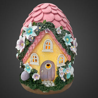 Gartenfigur in Ei‑Form mit gelbem Wichtelhaus, pinkem Dach, Blumenverzierung und Solar‑LED, 17 cm hoch. Beleuchtet mit grauen Hintergrund