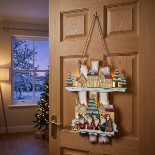 LED-Weihnachtsdekoration „Wichtelweihnacht“ (36 cm) mit Timer, farbige Holzszene mit Wichteln und Dorfmotiv, warm leuchtend als Türhänger in einem weihnachtlich dekorierten Wohnraum platziert.