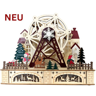 Holzdeko mit großem beleuchtetem Riesenrad, winterlicher Weihnachtsszene, Häusern im Hintergrund, Tannenbäumen, Rentier, Weihnachtsmannfigur und dekorativen Ausschnitten mit Hirschmotiven im Sockel; roter Schriftzug „NEU“ oben links.