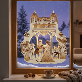 LED‑Fensterbild aus Holz mit Szene aus „Drei Haselnüsse für Aschenbrödel®“, farbig abgesetzt und warm beleuchtet. Dargestellt ist ein Tanzpaar unter einem Torbogen, umgeben von weiteren Figuren, Schlossarchitektur und dekorativen Elementen wie Eulen. Im Hintergrund ist eine verschneite Winterlandschaft am Fenster zu sehen; auf der Fensterbank stehen eine Tasse und winterliche Dekoration.