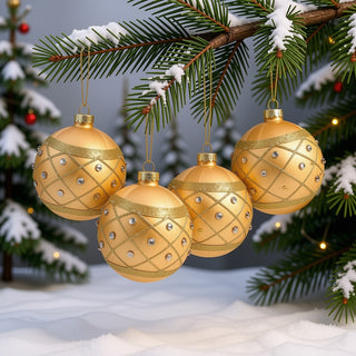 Vier goldfarbene Glaskugeln mit Eislack-Oberfläche hängen an einem verschneiten Tannenzweig. Die 8 cm großen Christbaumkugeln sind mit feinen goldenen Glitzerlinien in einem diagonalen Gittermuster sowie kleinen silberfarbenen Schmucksteinen verziert. Vor winterlicher Hintergrundkulisse wirkt das 4er-Set festlich und elegant.
