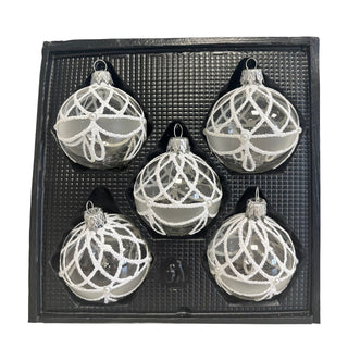 Fünf Christbaumkugeln aus Glas in Kristall-Weiß liegen in einer schwarzen Verpackungseinlage. Die transparenten Kugeln sind mit aufwendigen weißen Ornamenten versehen, die aus feinen Perlenlinien und geschwungenen Mustern bestehen. Zarte matte Akzente und kleine Perlendetails verleihen dem Dekor eine elegante, frostige Optik. Das 5-teilige Christbaumschmuck-Set erinnert an Eis- und Schneekristalle und sorgt für eine stilvolle, winterliche Weihnachtsdekoration.