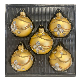 Fünf goldfarbene Christbaumkugeln aus Glas in einer schwarzen Verpackungseinlage. Die Kugeln besitzen eine matte Goldoberfläche und sind mit filigranen Perlenbändern, feinen goldenen Glitzerlinien sowie klaren, facettierten Schmucksteinen verziert. Die geschwungenen Dekorelemente und die luxuriösen Strassakzente verleihen dem 5-teiligen Christbaumschmuck-Set eine elegante und besonders festliche Ausstrahlung.