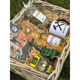 Präsentkorb „Himmelfahrt“ von SAICO mit geflochtenem Korb, Kaffeetasse „Glück auf“, Kräuterlikör, Kräutertee aus dem Erzgebirge, Räucherfigur Räucherbaum, Räucherkerzen „Ruhe“ und Servietten, dekorativ arrangiert. Detailfoto