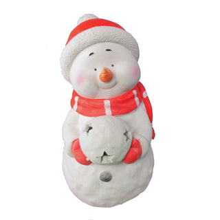 Dekofigur eines Schneemanns mit roter Mütze und rotem Schal, der einen beleuchtbaren Schneeball in den Händen hält.