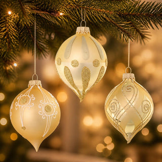 Christbaumschmuck-Glaskugelset in Zwiebelform, 3-teilig, in edlem Gold. Die drei handdekorierten Glasornamente zeigen unterschiedliche Muster mit Glitzerakzenten, Ornamentlinien und filigranen Verzierungen. Die elegante Zwiebelform und die festliche Farbgebung verleihen dem Weihnachtsbaum eine klassische und hochwertige Ausstrahlung.
