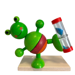 Zahnputzuhr „Frosch“ aus farbig bemaltem Holz, grüne Froschfigur mit integrierter Sanduhr, Höhe 11 cm.