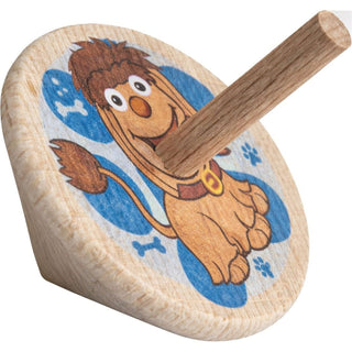 Holzkreisel ‚Moppi‘, 4 cm groß, farbig bedruckt. Auf der runden Scheibe ist die Hundfigur Moppi vor blauem Hintergrund mit Pfoten- und Knochenmotiven abgebildet; der Kreisel hat einen mittigen Holzstab.